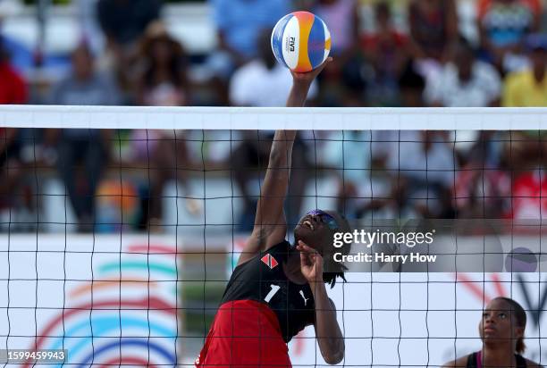 Fe Roberts of Team Trinidad and Tobago plays the ball near the net against Stephanie Joel and Eleno Moule of Team Vanuatu in the Women's Beach...