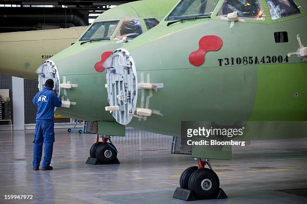 An employee works on an ATR 72 turboprop aircraft, manufactured by Avions de Transport Regional , at the company's production facility in Colomiers,...