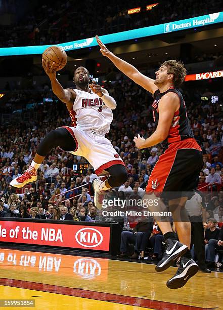 Dwyane Wade of the Miami Heat drives against Aaron Gray of the Toronto Raptors during a game at American Airlines Arena on January 23, 2013 in Miami,...