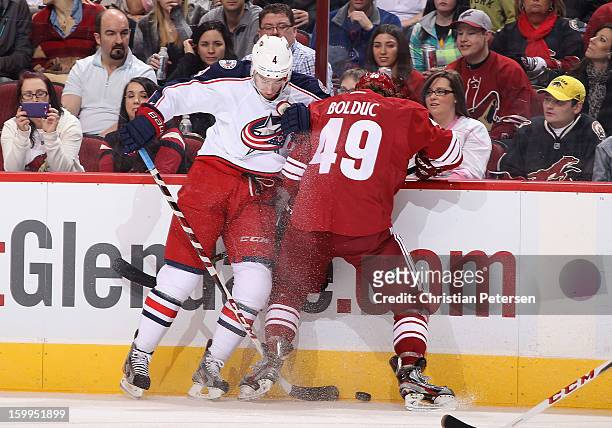 John Moore of the Columbus Blue Jackets battles for a loose puck with Alex Bolduc of the Phoenix Coyotes during the first period of the NHL game at...