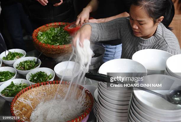 To go with "Vietnam-food-culture,FEATURE" by Cat Barton This picture taken on January 10, 2013 shows an employee placing pho noodles into bowls at...