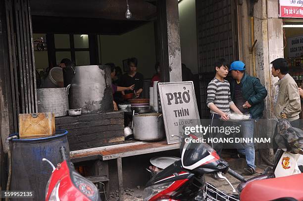 To go with "Vietnam-food-culture,FEATURE" by Cat Barton This picture taken on January 10, 2013 shows an employee carrying a tray of bowls of pho...