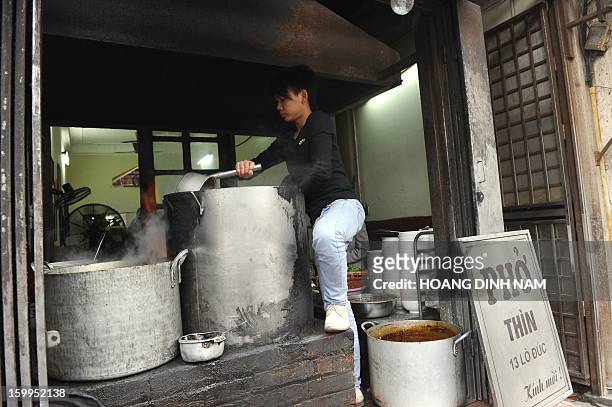 To go with "Vietnam-food-culture,FEATURE" by Cat Barton This picture taken on January 10, 2013 shows an employee inspecting big tanks of beef soup at...