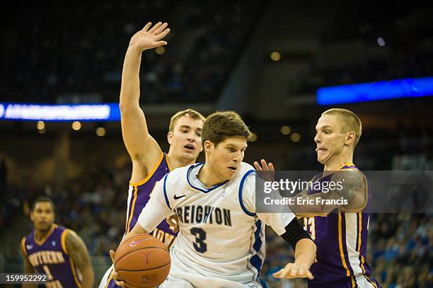 Doug McDermott of the Creighton Bluejays tries to work around Chip Rank and Marc Sonnen of the Northern Iowa Panthers during their game at the...