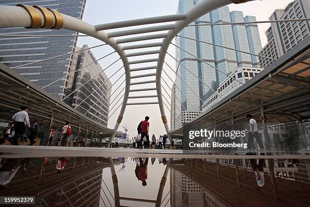 Commuters walk across a pedestrian bridge in the Sathorn district of Bangkok, Thailand, on Wednesday, Jan. 23, 2013. Prime Minister Yingluck...