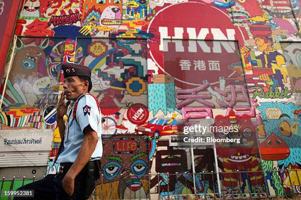 Security guard smokes a cigarette as he takes a break outside Hua Lamphong Metropolitan Rapid Transit station in Bangkok, Thailand, on Wednesday,...