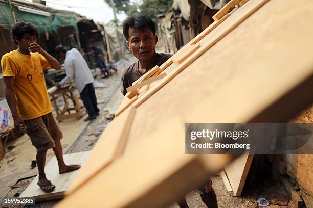 Carpenter carries lumber at a workshop in Bangkok, Thailand, on Wednesday, Jan. 23, 2013. Prime Minister Yingluck Shinawatra's government last month...