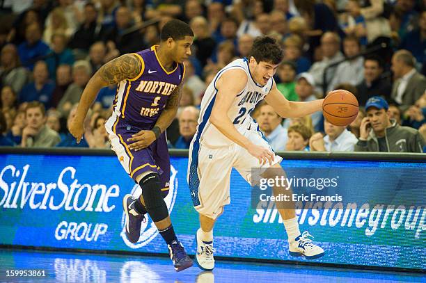 Avery Dingman of the Creighton Bluejays brings the ball up court past Deon Mitchell of the Northern Iowa Panthers during their game at the...