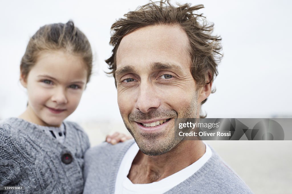 Father carrying daughter on the beach, portrait