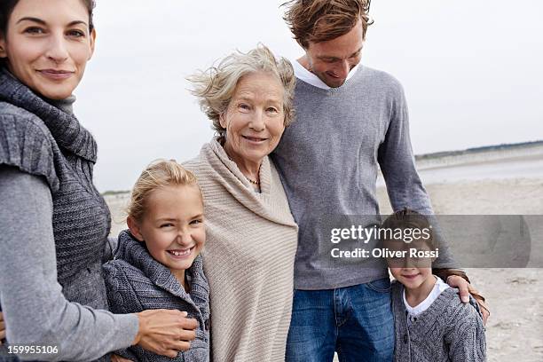 happy family with grandmother on the beach - familie mit mehreren generationen stock-fotos und bilder