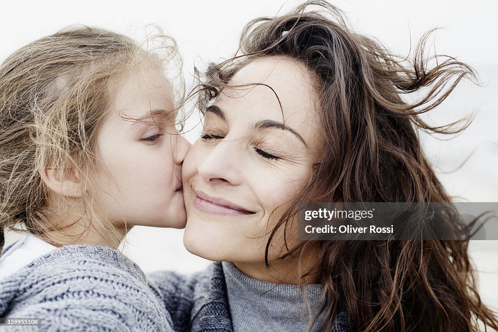 Daughter kissing mother outdoors