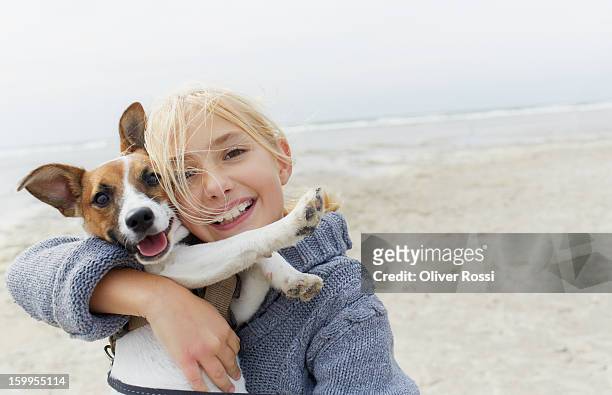happy girl hugging dog on the beach, portrait - hund stock-fotos und bilder