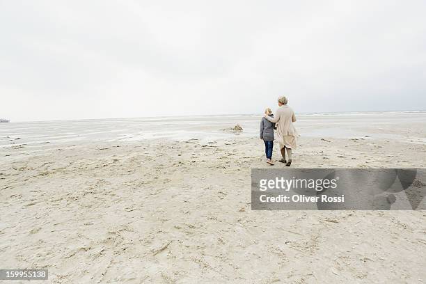 grandmother with granddaughter on the beach - granddaughter stockfoto's en -beelden