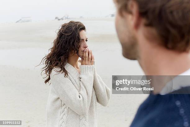 serious brunette woman and man on the beach - couple unhappy stock pictures, royalty-free photos & images