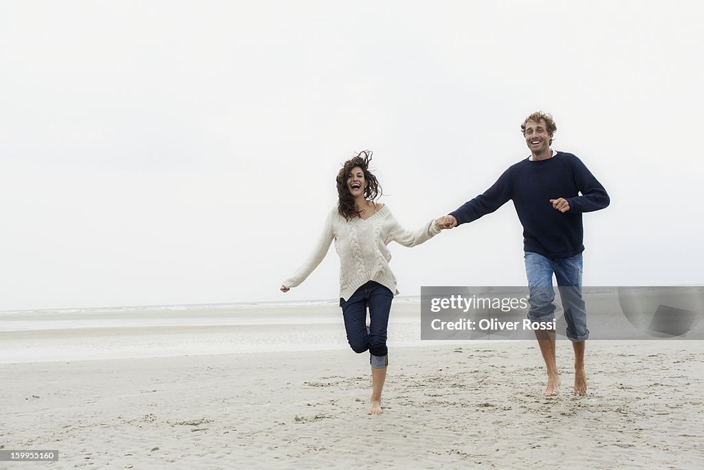 Happy couple running on the beach