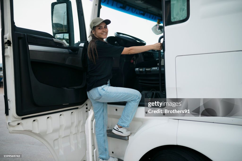 Semi-truck driver climbing into the truck cab