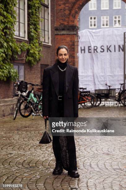 Ilenia Toma wearing a long maxi sheer dress, black boots, black turtle neck top, black jacket, and black YSL triangle bag outside Herskind during the...
