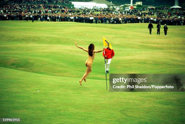 Female streaker grabs the pin at the British Open Golf Championship held at St Andrews, Scotland, circa July 2000.
