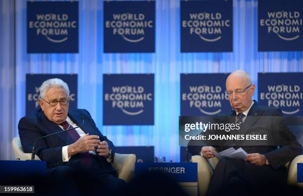 Former US secretary of state Henry Kissinger talks with World Economic Forum founder and host Klaus Schwab during a a session of the annual WEF...