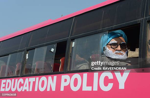 Man dressed as Indian Prime Minister Manmohan Singh sits in the 'Pink Bus' which launched the Campaign for Education as the solution to cure India's...