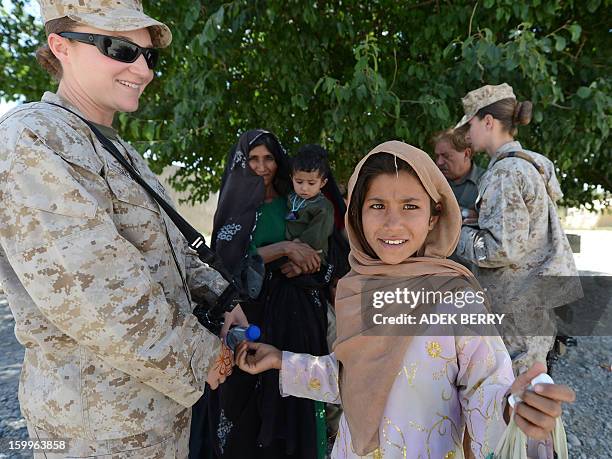 An Afghan girl interacts with US Marine HM2 Vanessa Siemasz during a meeting with Afghan women and members of the US Female Engagement Team of 1st...