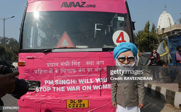 Man dressed as Indian Prime Minister Manmohan Singh stands in front of the 'Pink Bus' which launched the Campaign for Education as the solution to...