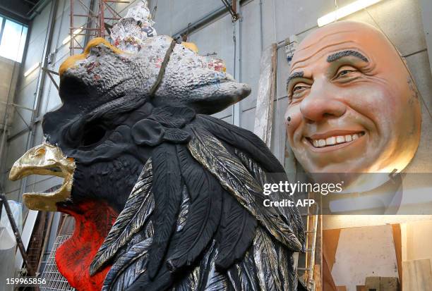 An old giant mask depicting Italian politician Silvio Berlusconi is displayed at the Cittadella del Carnevale, the workshops where the masks and...