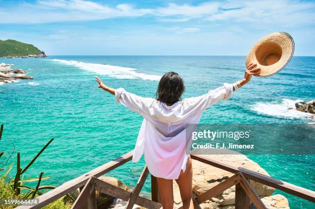 woman with arms raised with the sea in the background - cultura caribeña fotografías e imágenes de stock