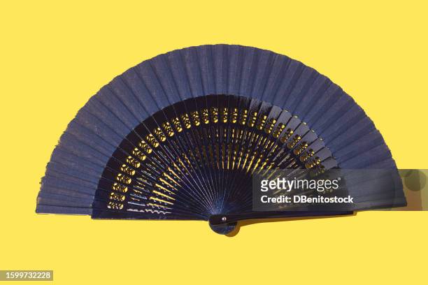 blue hand fan on yellow background. concept of heat, tradition, heat, wind, cool, cool off, wealth, asia and spain. - folding fan stock pictures, royalty-free photos & images