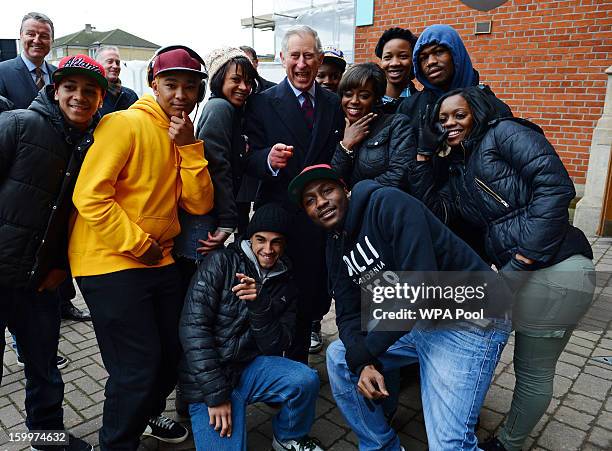 Prince Charles, Prince of Wales poses for photographs with local youths who take part in The Prince's Trust activities during a visit to Surrey...