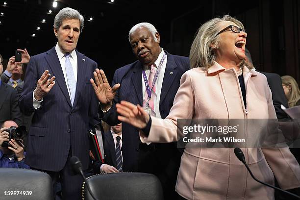 Sen. John Kerry talks with committee staffer Bertie Bowman as U.S. Secretary of State Hillary Clinton has a laugh before Kerry's confirmation hearing...