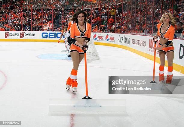 Caitlin Quack and Kimberly Webb of the Philadelphia Flyers ice girls clean the ice during a timeout against the Pittsburgh Penguins on January 19,...