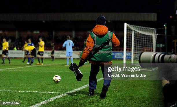Photographer returns the ball as no ball boy at hand during the npower League Two match between AFC Wimbledon and Port Vale at The Cherry Red Records...