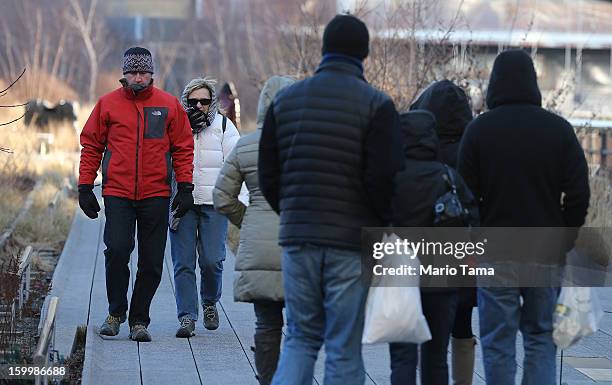 People bundled up against the cold walk through the High Line park in Manhattan on January 24, 2013 in New York City. Polar air settled in over the...