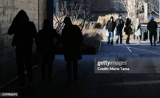 People bundled up against the cold walk through the High Line park in Manhattan on January 24, 2013 in New York City. Polar air settled in over the...