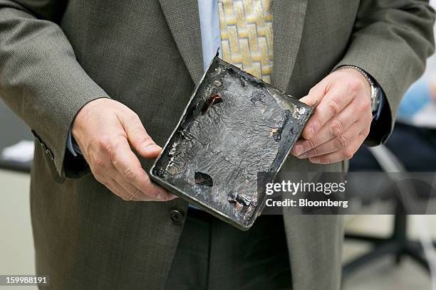 Joseph Kolly, director of research and engineering with the National Transportation Safety Board , holds a damaged battery cell case from a Japan...