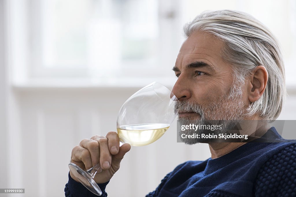 Mature man with a glass of white wine