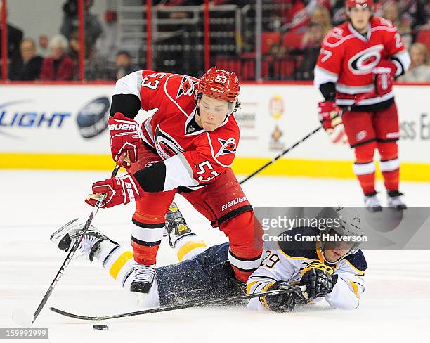 Jeff Skinner of the Carolina Hurricanes takes the puck away from Jason Pominville of the Buffalo Sabres during play at PNC Arena on January 24, 2013...