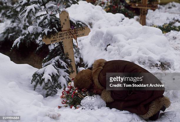 Woman grieving in a Bucharest cemetery shortly after the Romanian Revolution, 1990.