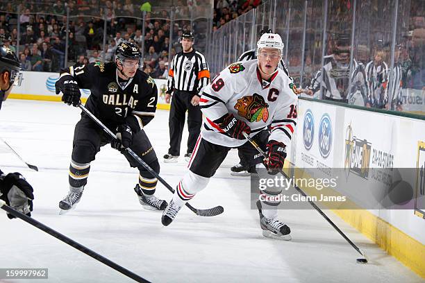 Jonathan Toews of the Chicago Blackhawks looks to pass to a teammate against Loui Eriksson of the Dallas Stars at the American Airlines Center on...