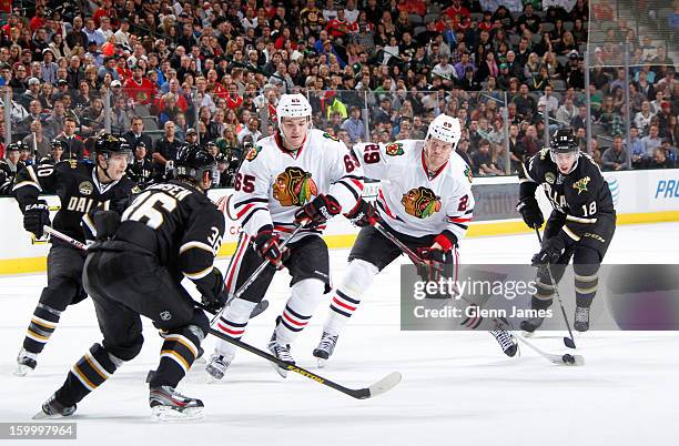 Brian Bickell of the Chicago Blackhawks winds up a shot against Philip Larsen and Reilly Smith of the Dallas Stars at the American Airlines Center on...