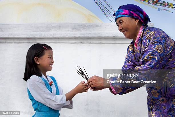 nepali grandmother giving incense to granddaughter - nepal family stock pictures, royalty-free photos & images