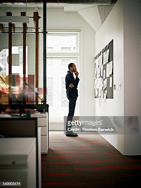 businessman in office examining project on board - inspiration board stock pictures, royalty-free photos & images
