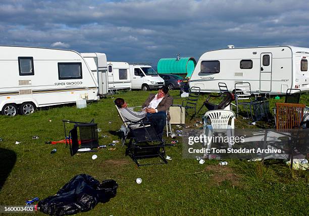 6th JUNE 2011: Two revellers asleep as the sun rises over their caravans at Appleby Horse Fair. The travellers had partied long into the night to...