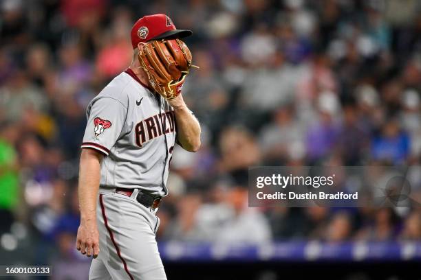 Merrill Kelly of the Arizona Diamondbacks yells into his glove as he walks off the field after pitching the sixth inning against the Colorado Rockies...