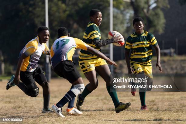 Tshepo Mdaki from Soweto Jabulani Technical Secondary School U16 rugby team runs with the ball as Ntando Manentsa follows during a match against...