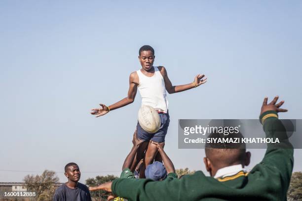 Lwazi Tshazi of the U16 Jabulani Technical Secondary School rugby team reaches for the ball during a rugby practice at in Soweto on April 20, 2023....