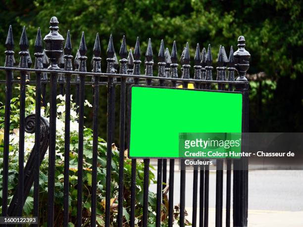 empty and green street name sign on a wrought iron gate on a street corner in london, england, united kingdom - commercial sign stock illustrations stock pictures, royalty-free photos & images