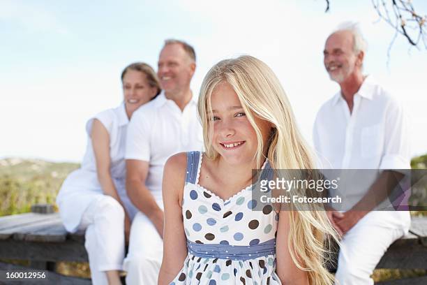 beautiful girl with her family - front view portrait of four children sitting on rock stock pictures, royalty-free photos & images