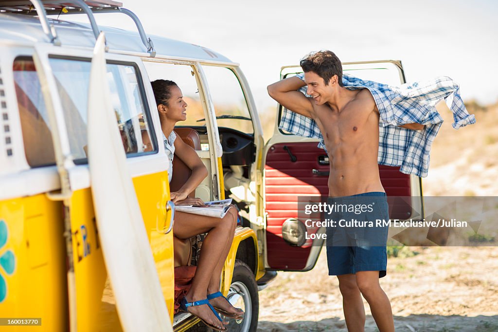Couple talking outside van on beach